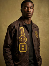 Load image into Gallery viewer, Man wearing a brown jacket with yellow and green designs on a beige background