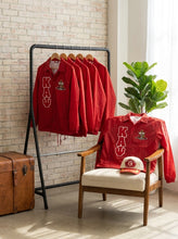 Load image into Gallery viewer, Red shirts with 'KAY' branding on a rack and chair against a brick wall.