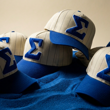 Load image into Gallery viewer, Baseball caps with blue and white designs on a textured surface