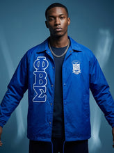 Load image into Gallery viewer, Man wearing a blue jacket with Phi Beta Sigma letters against a blue background

